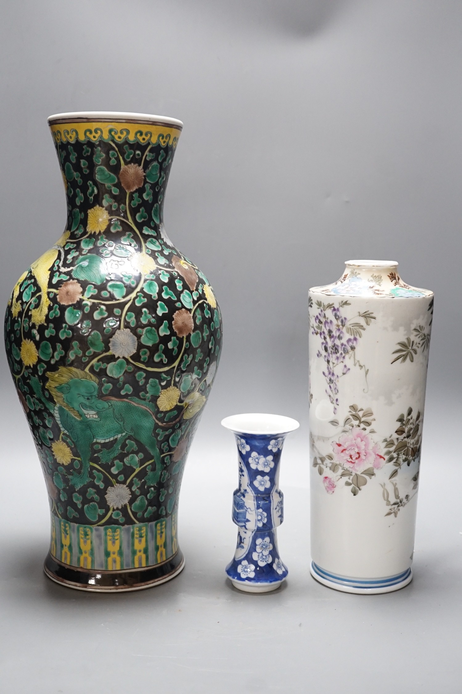 A Chinese famille noire vase, a Chinese blue and white small gu vase and a Japanese cylindrical vase, tallest 43cms high